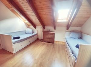 比利亚努阿Duplex Familiar Izarraitz的一间卧室设有两张床和木制天花板