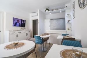 兰佩杜萨Domus B&B Le Nereidi的客厅配有2张桌子和椅子以及电视