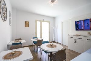 兰佩杜萨Domus B&B Le Nereidi的一间客厅,客厅内配有两张桌子和椅子