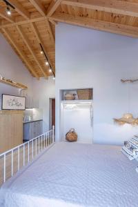 哈尔基岛Althea Apartments 2的一间设有一张大床的客房,拥有木制天花板