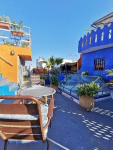 丹吉尔Bayt Alice Hostel的一个带桌椅的庭院和一座蓝色建筑