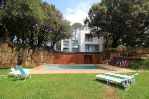 擞莫Apartamento 2 dormitorios con piscina y jardín的一座带游泳池和两把草坪椅的房屋