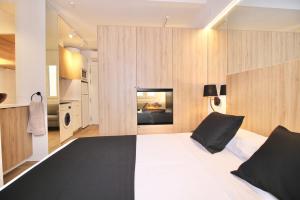 塔拉戈纳ESTUDIO PORT EXPERIENCE的卧室设有黑白色的床和木墙