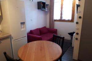艾姆拉普拉涅Appartement confortable face à la montagne的客厅配有桌子和红色沙发