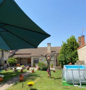 Sancti SpíritusCasa rural del labrador的一个带游泳池的庭院里的一个大型绿伞