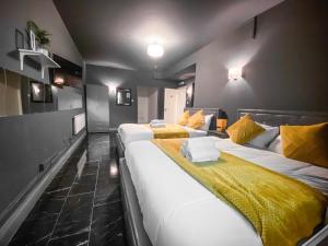 伦敦Wns HOTEL的酒店客房带两张带黄床单的床