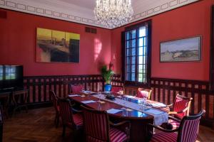 纳龙Hotel Pazo Libunca的一间拥有红色墙壁和桌椅的用餐室