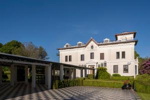 纳龙Hotel Pazo Libunca的一座白色的大房子,前面有一个庭院