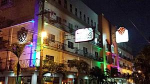 塔帕丘拉Hotel San Francisco的街上的一座建筑物,晚上有五颜六色的灯光