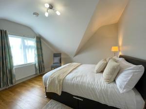 卡文Drumlanaught Cottage Farnham的一间卧室设有一张大床和一个窗户。