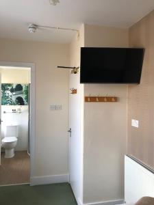 TarvesThe Aberdeen Arms Hotel的一间带卫生间的浴室和墙上的电视