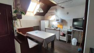 桑托德Oázis Apartman的一间带桌子的小厨房和一间带电视的小厨房