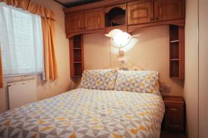波特拉什Aaranmore Mobile Home的一间卧室配有一张位于上面的光线的床