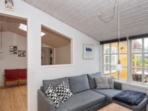 孔斯马克8 person holiday home in R m的客厅设有灰色的沙发和窗户。