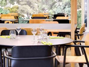 帕讷Hôtel ibis Styles Montargis Arboria的餐厅设有桌椅和酒杯