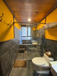鱼池乡涌泉民宿的浴室设有卫生间和带黄色墙壁的淋浴。