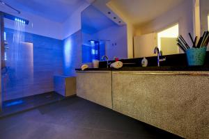 圣玛格丽塔-利古雷LA STANZA IN PIAZZETTA的浴室配有水槽和带蓝色灯光的淋浴