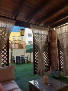 马拉加Ático Chill Out la Biznaga的庭院里设有窗帘和桌子