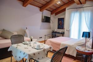 Rosà罗莎德尔格拉帕住宿加早餐旅馆的卧室配有一张床和一张桌子及椅子