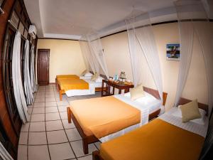 Rabia瓦伊沃拉贾安帕潜水假日公园的酒店客房设有三张床和一张桌子