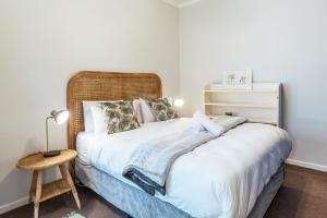 开普敦Spacious Gem, Outdoor Space, Close to TBMTN&City的卧室配有白色的床和木制床头板