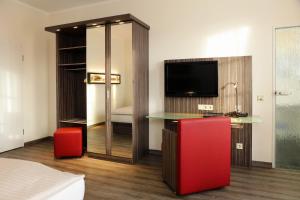 阿希姆格里斯切酒店的配有书桌和电视的酒店客房