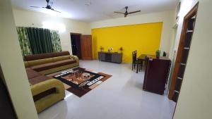 蒂鲁帕蒂Tirupati Homestay - 2BHK AC Family Apartments near Alipiri and Kapilatheertham - Walk to A2B Veg Restaurant - Super fast WiFi - Android TV - 250 Jio Channels - Easy access to Tirumala的客厅配有沙发和桌子