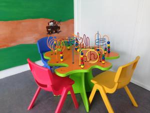Jelling耶林家庭露营别墅酒店的一张桌子,上面摆放着五颜六色的椅子和一套游戏