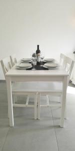 博扎瓦Island Cottage Apartment的一张带盘子和酒杯的白色桌子