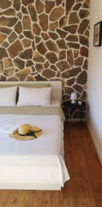 博扎瓦Island Cottage Apartment的酒店客房,配有带帽子的床