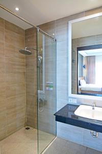 日惹Queen of the South Beach Resort的带淋浴、盥洗盆和镜子的浴室