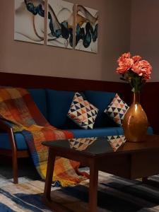 泰布克Biz Hotel Apartments的一张带桌子的蓝色沙发以及花瓶