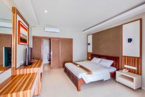 日惹Queen of the South Beach Resort的一间卧室配有一张床和一台平面电视
