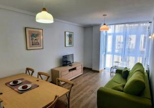 桑坦德Apartamento en Reina Victoria的客厅配有绿色沙发和桌子