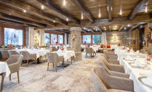 蒂罗尔-泽费尔德泽费尔德百乐酒店的餐厅设有白色的桌椅和窗户。