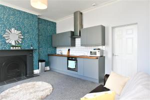 切尔滕纳姆Albion Street Serviced Apartments的客厅设有带壁炉的厨房