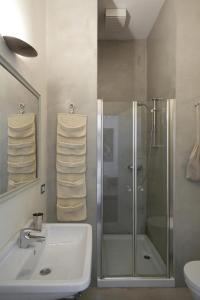 科莫卡娜瑞纳住宿加早餐酒店 的一间带玻璃淋浴和水槽的浴室