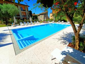 布雷佐内加尔达Hotel Villa Isabella的度假村内带躺椅的大型游泳池