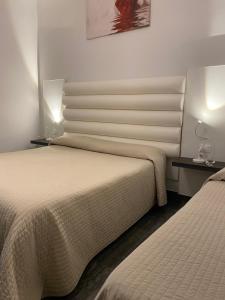 贾迪尼-纳克索斯Tysandros Hotel Apartments的酒店客房设有两张床和两盏灯。