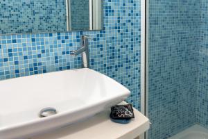 卡萨拉诺Tenuta Andromeda的蓝色瓷砖浴室设有水槽和淋浴