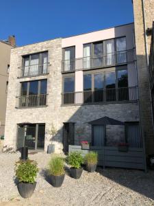 杜柏Le Durbuysien的公寓大楼设有阳台和盆栽植物