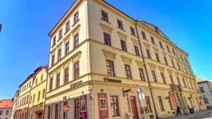 赫拉德茨 - 克拉洛韦博曼公寓式酒店的街道边的黄色大建筑