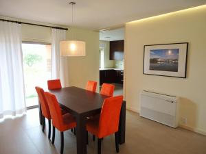 斯代塔维拉Anis Lux Tavira Residence Villa 5M的一间带桌子和橙色椅子的用餐室