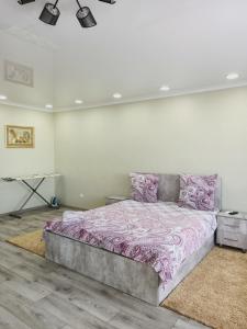 乌斯季卡缅诺戈尔斯克ApartNew in City Centr的一间卧室配有一张带粉红色床单的大床