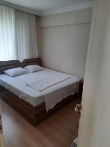 恰纳卡莱ADA APART OTEL的一间卧室配有一张带白色床单的床和一扇窗户。