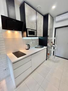 敖德萨Апартаменты в Аркадии - Arcadia Sky Apartments的白色的厨房配有水槽和微波炉