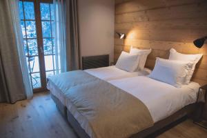 拉克吕萨农场酒店的卧室配有一张带白色床单和枕头的大床。