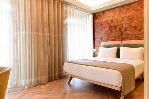 里斯本我的故事特茹酒店的一间卧室配有一张砖墙床