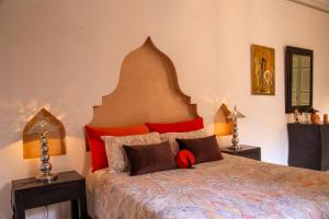 马拉喀什RIAD KERDOUSS的一间卧室配有一张带红色枕头的大床