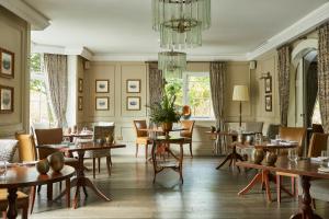 安布尔塞德罗塞庄园酒店的一间带桌椅和吊灯的用餐室